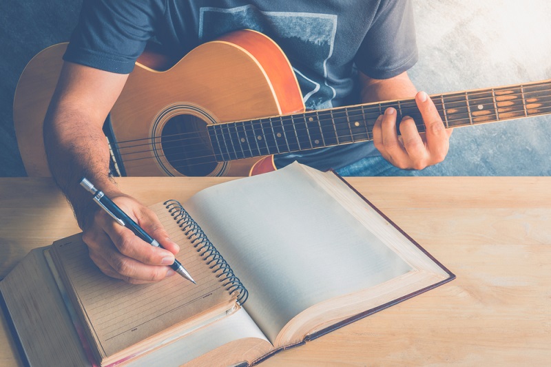 Writing a song with guitar pen and paper